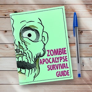 May include: A green notebook with a zombie face on the front. The text "Zombie Apocalypse Survival Guide" is printed in pink letters.