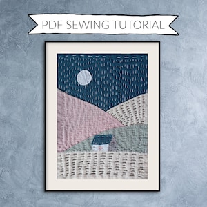 May include: Framed textile art depicting a night landscape with a full moon, hills, and a small house. The artwork is stitched with various colors of thread, including blue, pink, and white. The text "PDF SEWING TUTORIAL" is above the frame.