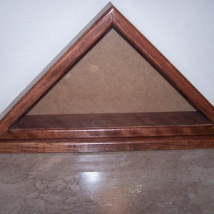 May include: A wooden triangular shadow box with a glass front and a shelf inside. The box is stained a dark brown color.