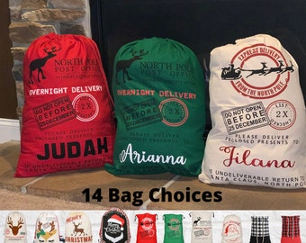 May include: Four red, green, and white Santa sacks with the text "North Pole Post Office" and "Overnight Delivery". The sacks have personalised names: Judah, Arianna, and Filana.  The text "Do Not Open Before 25 December" is on each sack.  Below the sacks is a row of 10 smaller Santa sacks with various designs, including reindeer, Santa, and Christmas trees. The text "14 Bag Choices" is below the smaller sacks.