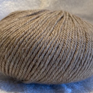 May include: A ball of beige yarn, ready for knitting or crocheting.