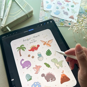 May include: A digital illustration of a sticker sheet featuring a variety of cute dinosaur designs. The sheet includes a variety of dinosaurs, including a triceratops, a stegosaurus, a pterodactyl, and a T-Rex. The sheet also includes a palm tree, a volcano, and a dinosaur egg. The sheet is titled "Angel + Hare Dino Sticker Sheet" and includes the website address "angelandhare.com".