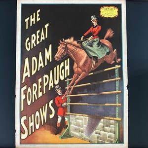 May include: A vintage circus poster for The Great Adam Forepaugh Shows featuring a brown horse jumping over a hurdle. A rider in a red jacket and top hat sits on the horse, while a man in a red uniform stands below. Text reads Filemaker Champion.