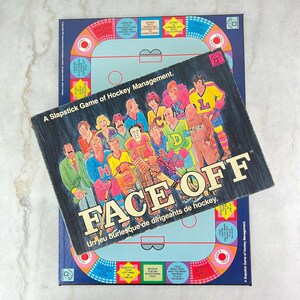 Puede incluir: Un juego de mesa vintage llamado "Face Off" con un diseño de pista de hockey colorido. El juego es un juego de gestión de hockey de comedia. La caja presenta una ilustración de dibujos animados de un equipo de hockey.