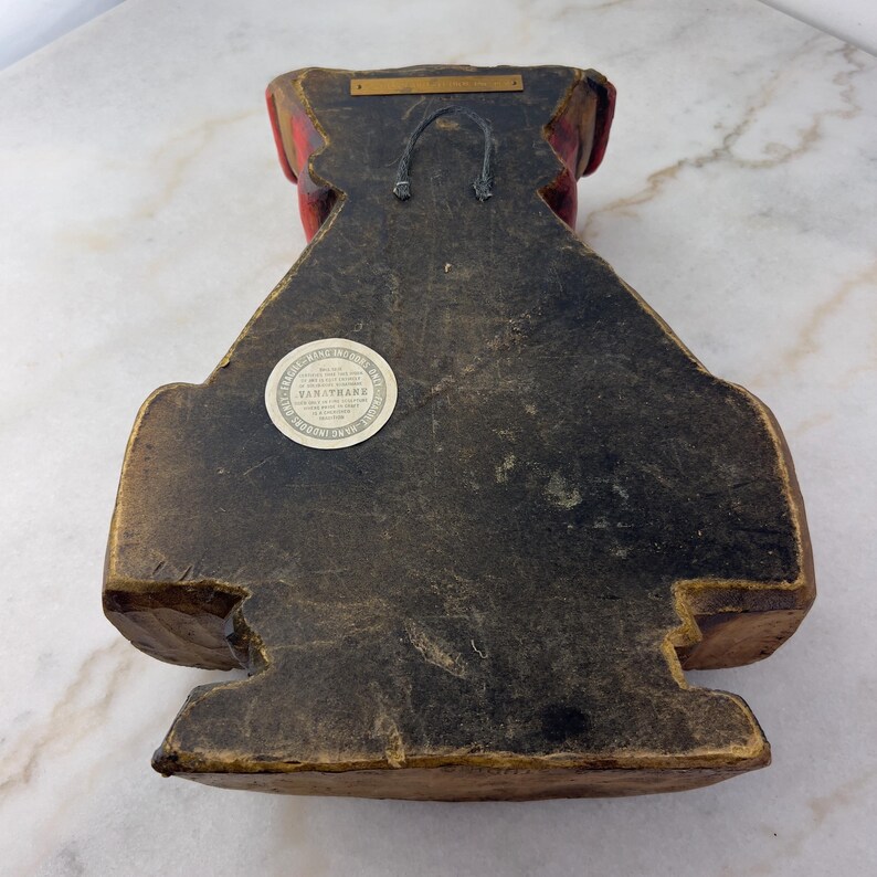 May include: A wooden wall sculpture of a red-headed man with a black beard and moustache. The sculpture is painted in shades of red, brown, and black. The back of the sculpture has a label that reads "Van Thane, Inc. Made in USA."