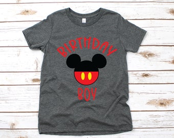 May include: A dark gray t-shirt with a red Mickey Mouse head and the words "Birthday Boy" in red.