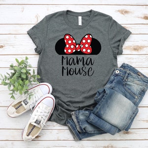 May include: A grey t-shirt with a black silhouette of Mickey Mouse ears with a red bow with white polka dots. The text "Mama Mouse" is printed in black below the ears.