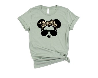 May include: A sage green t-shirt with a black and white graphic of a cartoon mouse wearing sunglasses and a leopard print bandana.