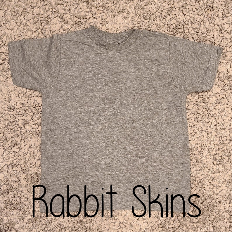 May include: A heather gray t-shirt with the text "Rabbit Skins" printed on the bottom.