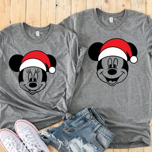 May include: Two gray t-shirts with a black and white image of Mickey Mouse wearing a red Santa hat.