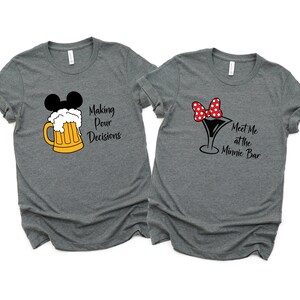 Könnte beinhalten: Zwei graue T-Shirts mit einem Mickey-Mouse-Motiv. Ein Shirt sagt "Making Pour Decisions" mit einem Bierkrug. Das andere Shirt sagt "Meet Me at the Minnie Bar" mit einem Martini-Glas.