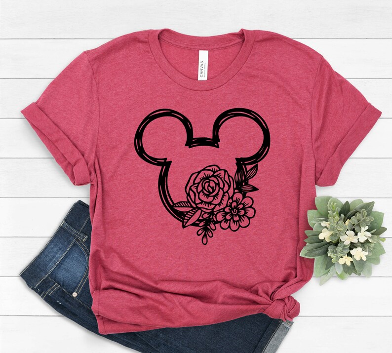May include: A red t-shirt with a black outline of Mickey Mouse ears with floral accents.
