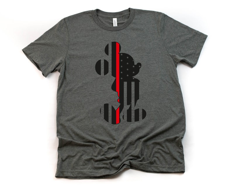 May include: A dark grey t-shirt featuring a black silhouette of Mickey Mouse. The silhouette is filled with an American flag pattern with a red line down the centre.