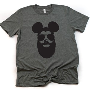 May include: A dark grey t-shirt featuring a black silhouette of Mickey Mouse wearing sunglasses and a beard.