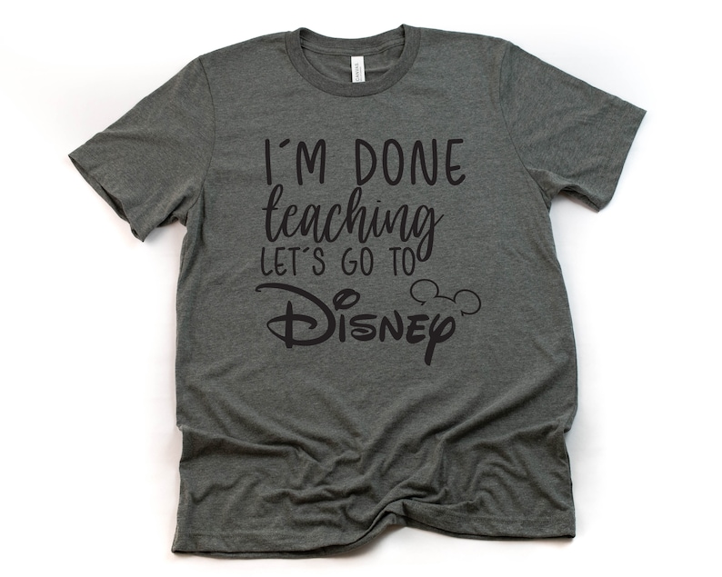 May include: A dark gray t-shirt with the text "I'm done teaching let's go to Disney" in black lettering. The text includes a Mickey Mouse head icon.