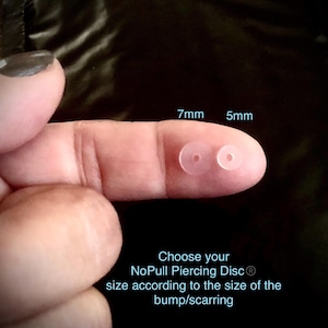 May include: Two clear, circular NoPull Piercing Discs, 7mm and 5mm, are displayed on a finger. The text reads, "Choose your NoPull Piercing Disc size according to the size of the bump/scarring."