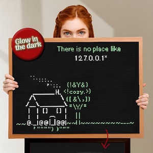 Pode incluir: Um quadro-negro preto com moldura de madeira exibe arte de pixel branca de uma casa e o texto "There is no place like 127.0.0.1*". Um círculo vermelho com "Glow in the dark" está no canto superior esquerdo.