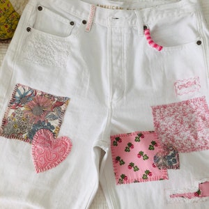 Patched and embroidered white denim jeans