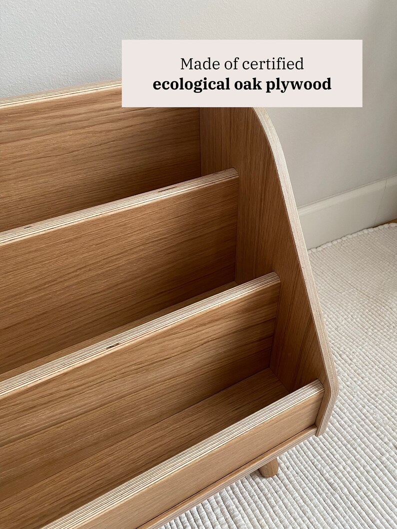 Puede incluir: Una estanter&iacute;a de madera con tres estantes, hecha de madera contrachapada de roble ecol&oacute;gico certificada. Los estantes son curvos en la parte superior y tienen un acabado de madera natural.