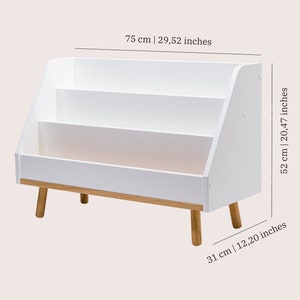 Puede incluir: Estanter&iacute;a blanca con tres estantes y una base de madera. La estanter&iacute;a mide 75 cm de ancho, 52 cm de alto y 31 cm de profundidad.