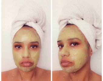 May include: A face with a light green, smooth-textured facial mask applied across the forehead, cheeks, nose, and chin. A white towel is wrapped securely around the head in a turban style, covering the hair completely while leaving the face exposed.