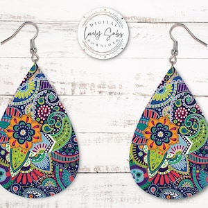 May include: A pair of teardrop-shaped earrings with a colorful paisley pattern. The earrings are made of metal and have a silver hook closure.