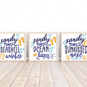 May include: Three wooden framed prints with a beach theme. Each print features the text "sandy toes" and a different phrase: "seashell wishes", "ocean kisses", and "sunkissed nose".