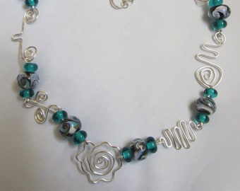 Teal glass bead choker on teal aluminum wire.