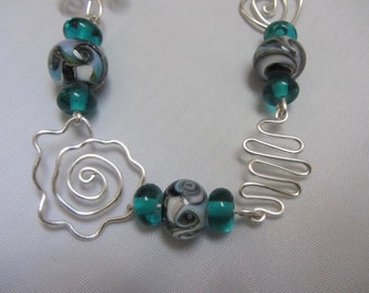 Handcrafted Lampworked Glass Bead Necklace, 7 cosmic blue/blk beads, 14 teal beads, wire work, base metal jump rings & hook clasp