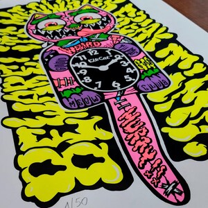K&ouml;nnte beinhalten: Ein lebendiger Pop-Art-Druck mit einer rosa katzenf&ouml;rmigen Uhr mit den Worten "WEIRD" und "HURRY UP" in fetter Schrift. Das Zifferblatt zeigt die Uhrzeit und die Worte "Kid Cat Club". Der Hintergrund ist eine Mischung aus gelben und schwarzen Formen.