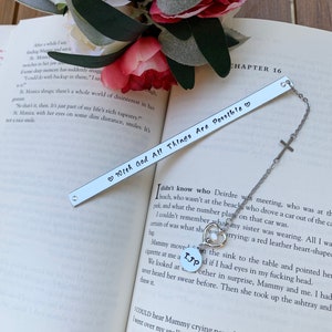 Pu&ograve; includere: Segnalibro d'argento con un cuore e il testo "With God All Things Are Possible" su sfondo bianco. Il segnalibro &egrave; attaccato a una catena d'argento con un ciondolo a forma di croce.