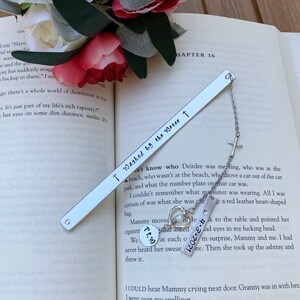 Pu&ograve; includere: Un segnalibro d'argento con un ciondolo a forma di croce e un ciondolo a forma di cuore. Il segnalibro &egrave; inciso con il testo "I Washed by the Water t".