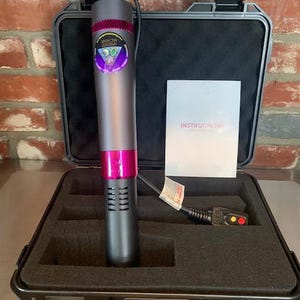 May include: A gray and pink immersion circulator with a black power cord and control panel, inside a black case. The circulator has a label that reads "Rainbow Cuisine". A white instruction manual is also included.