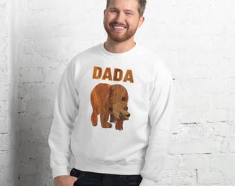May include: White sweatshirt with the word "DADA" printed in brown letters. A brown bear illustration is below the text.