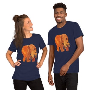 May include: Two people wearing navy blue t-shirts with a brown bear graphic. The bear is made of wood and has a textured surface.