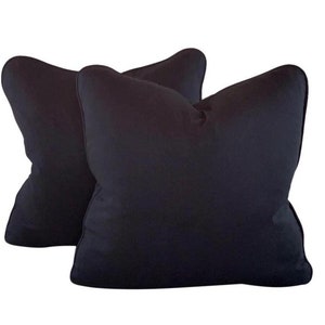 May include: Two black throw pillows with a soft, plush fabric. The pillows are rectangular and have a simple, classic design.