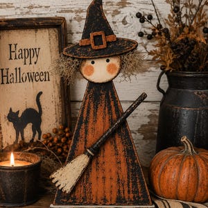 May include: A wooden Halloween witch figurine with a black hat and orange dress, holding a broom. The figurine has a rustic, distressed finish. A lit candle, a pumpkin, and a sign that says "Happy Halloween" are also in the image.