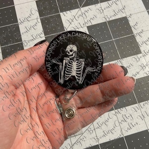 May include: A black and white retractable badge holder with a skeleton graphic and the text "That sounds like a day shift opportunity".