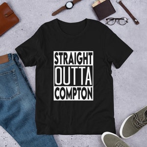 May include: Black t-shirt with white text that reads "STRAIGHT OUTTA COMPTON" in a box.