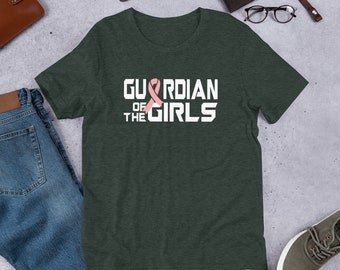 May include: A dark green t-shirt with the text "Guardian of the Girls" in white letters. A pink ribbon is superimposed over the word "Guardian".