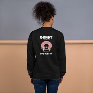 May include: Black sweatshirt with a pink donut graphic and the text "Donut of Truth Operator" printed on the back.