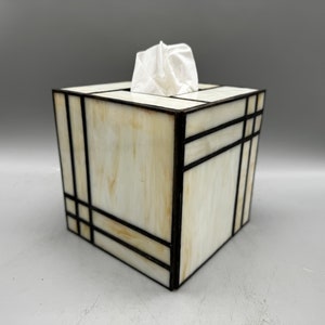 May include: A white tissue box cover with black geometric lines. The cover is made of stained glass and has a modern design.