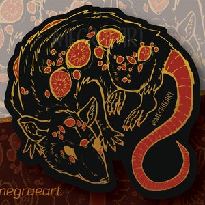 May include: A black and red rat sticker with gold details. The rat has multiple eyes and a curled tail. The sticker has the text "@megraeart" on the bottom.