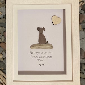 May include: A framed pebble art memorial with a brown dog silhouette, a wooden heart, and the text "No longer by our side Forever in our hearts Rover" with paw prints.