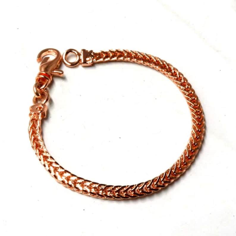 Peut inclure: Un bracelet en cha&icirc;ne or rose avec une fermeture &agrave; fermoir. La cha&icirc;ne est de conception tress&eacute;e.
