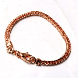 Peut inclure: Un bracelet en cha&icirc;ne en or rose avec une fermeture &agrave; fermoir. La cha&icirc;ne est de conception tiss&eacute;e.