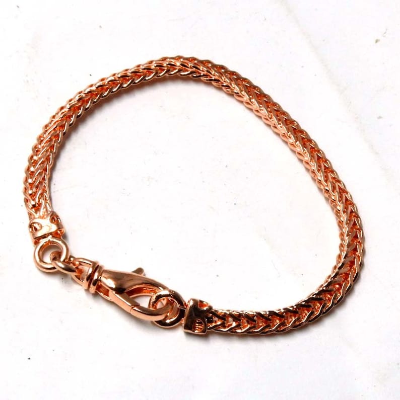 Peut inclure: Un bracelet en cha&icirc;ne en or rose avec une fermeture &agrave; fermoir. La cha&icirc;ne est de conception tiss&eacute;e.