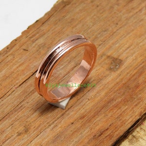 Pode incluir: Um anel de banda simples de ouro rosa com um design de dupla ranhura.