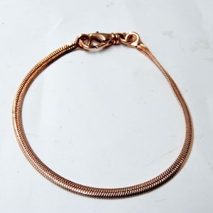 Puede incluir: Un brazalete de cadena de serpiente de oro rosa con cierre de langosta.