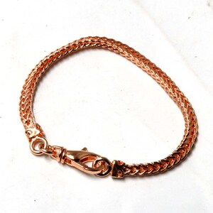 Peut inclure: Un bracelet en cha&icirc;ne or rose avec une fermeture &agrave; fermoir. La cha&icirc;ne est de conception tress&eacute;e.